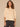 Macadamia Below Elbow Blouson Sleeve Round Neck Half Button Placket Embroidered Front Pleated Back Shirttail Hem Woven Top